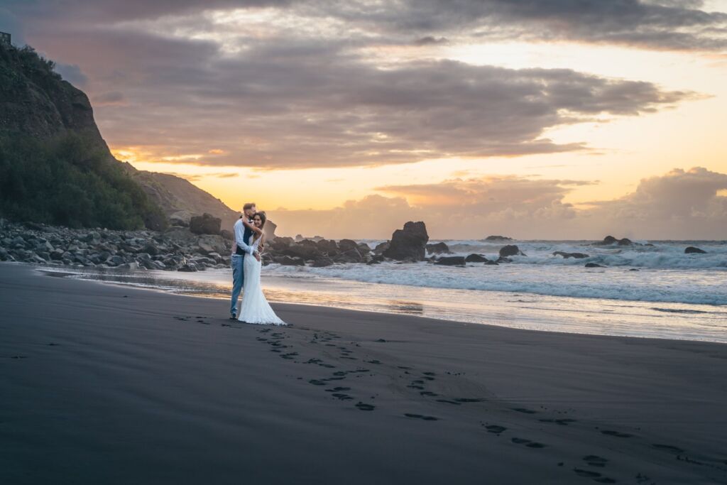 Postboda en Tenerife: Irina y David en Almáciga 14 Postboda en Tenerife: Irina y David abrazados al atardecer con sus huellas en la arena negra