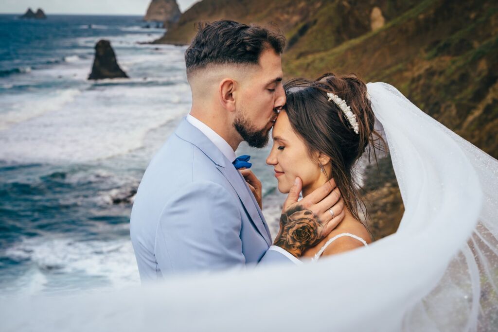 Postboda en Tenerife: Irina y David en Almáciga 6 Postboda en Tenerife: David besando la frente de Irina con el velo ondeando
