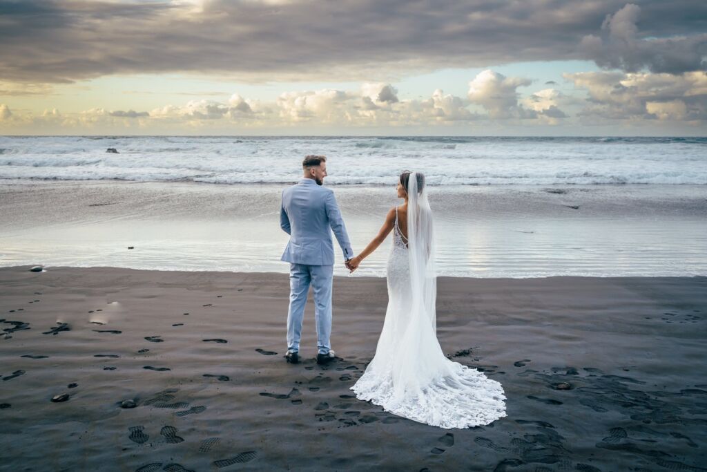 Postboda en Tenerife: Irina y David en Almáciga 9 Postboda en Tenerife: Irina y David caminando de la mano por la arena negra hacia el mar en Almáciga
