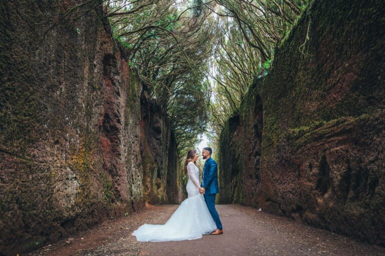Cómo trabajo: fotógrafo bodas en Tenerife 13 Novios mirándose entre paredes de roca cubiertas de musgo en un sendero de la laurisilva de Anaga durante su postboda en Tenerife