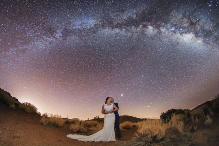Cómo trabajo: fotógrafo bodas en Tenerife 31 Pareja de novios abrazándose bajo el arco completo de la Vía Láctea durante su sesión nocturna de postboda en Tenerife