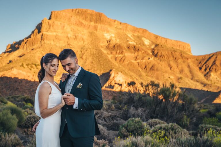 Cómo trabajo: fotógrafo bodas en Tenerife 24 Novios sonriendo con las frentes juntas ante las paredes volcánicas doradas de las Cañadas del Teide, durante su sesión de postboda en Tenerife