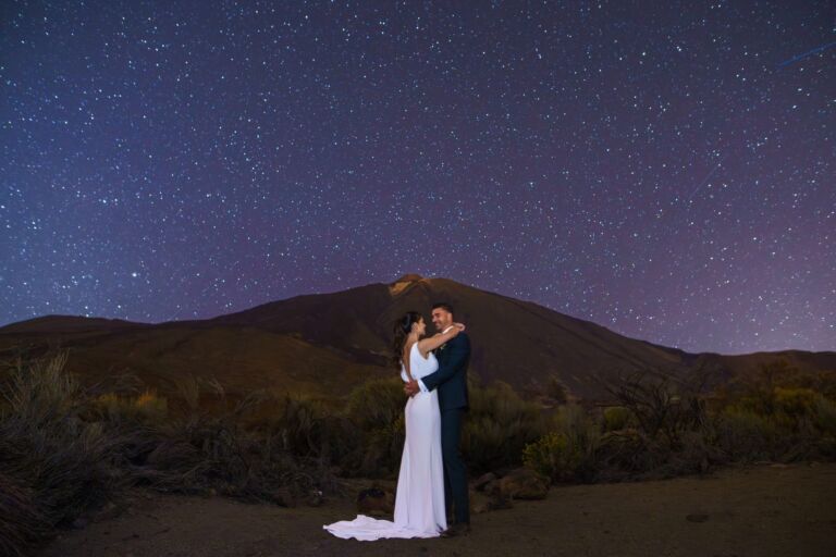 Cómo trabajo: fotógrafo bodas en Tenerife 28 Novios abrazándose de noche en el Parque Nacional del Teide bajo un cielo lleno de estrellas, durante su sesión de postboda en Tenerife